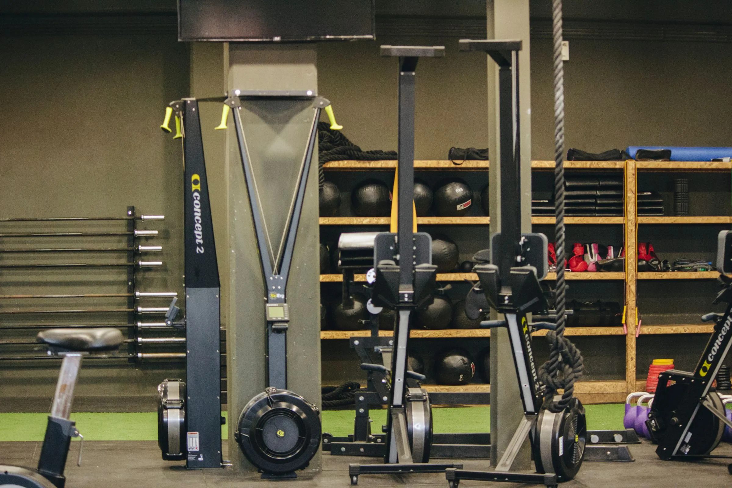 The gym floor: rowers, bikes, a climbing rope and shelves of kettlebells and medicine balls.